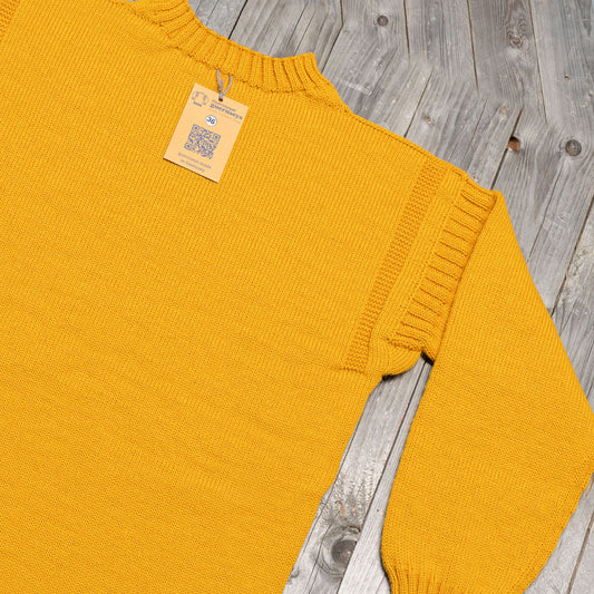 Traditional Scattered Lichen yellow wool guernsey sweater with ribbed shoulder detail and size 36 tag on wooden background.